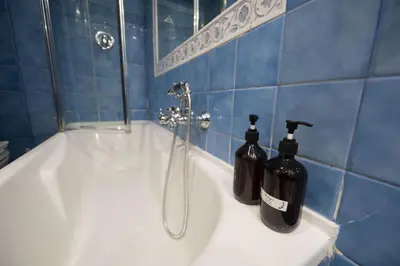 a bathroom with a bath tub with two bottles on it at Trastevere Charming Apartment in Rome