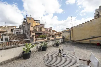 a table and a bottle of wine on a rooftop at Trastevere Charming Apartment in Rome