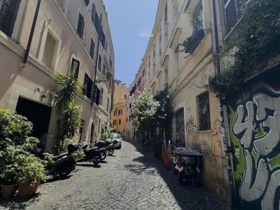 an alley with graffiti on the side of buildings at Trastevere Charming Apartment in Rome
