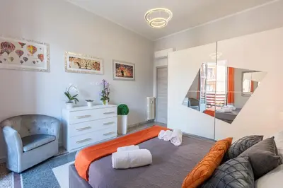 a bedroom with a king sized bed and a chair at Imperial House - 300m to Metro B, Open view, 4-6pax in Rome