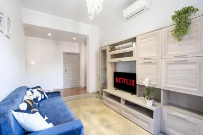 a living room with a blue couch and a tv at Imperial House - 300m to Metro B, Open view, 4-6pax in Rome