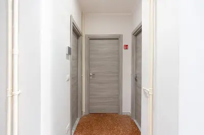 a corridor with a door in a white hallway at Imperial House - 300m to Metro B, Open view, 4-6pax in Rome