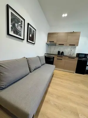 a couch in a living room with a kitchen at Scala 37 interno 1, Trastevere, Rome in Rome