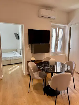 a living room with a table and chairs and a bed at Scala 37 interno 1, Trastevere, Rome in Rome