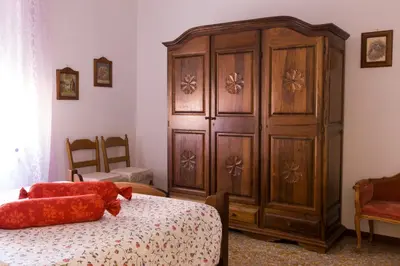 a bedroom with a large wooden cabinet next to a bed at Apartment in the center of Rome with spectacular view of the Dome in Rome