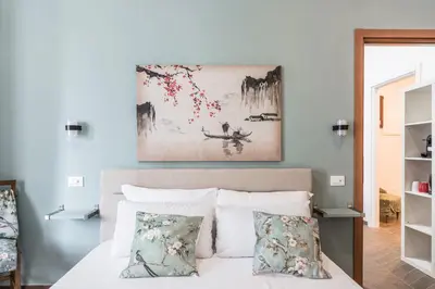 a bedroom with a bed with a painting above it at 59 Riverside in Rome