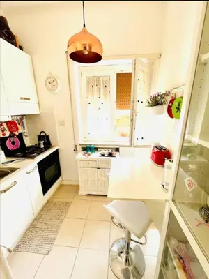 a white kitchen with a table and a window at Amazing Roma Vaticano in Rome