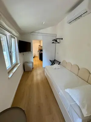 a bedroom with a white bed and a television at Scala 37 interno 2, Trastevere, Rome in Rome