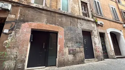 an old brick building with two doors on a street at Scala 37 interno 2, Trastevere, Rome in Rome