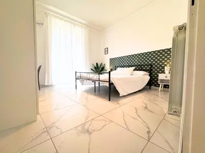 a large white room with a bed and a table at Trastevere Home in Rome