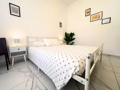 a white bed in a white bedroom with a night stand at Trastevere Home in Rome