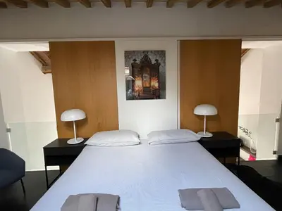 a bedroom with a large white bed with two lamps at Monti luxury penthouse in Rome