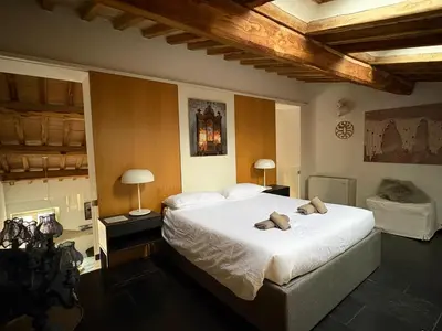 a bedroom with a large white bed and two lamps at Monti luxury penthouse in Rome