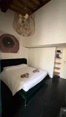 a bedroom with a white bed with two towels on it at Monti luxury penthouse in Rome