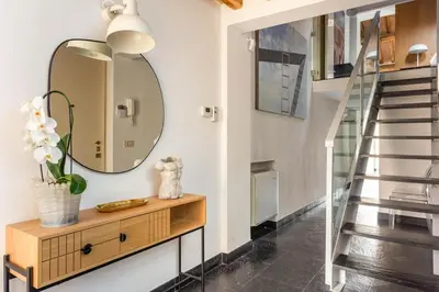 a mirror on a wall next to a stairway at Monti luxury penthouse in Rome