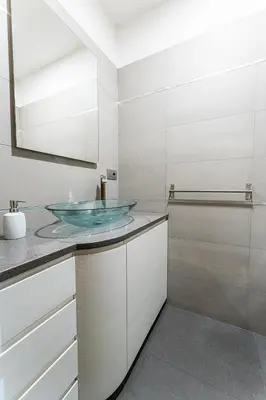 a bathroom with a glass sink and white cabinets at Domus Villae Rome Spanish Steps in Rome