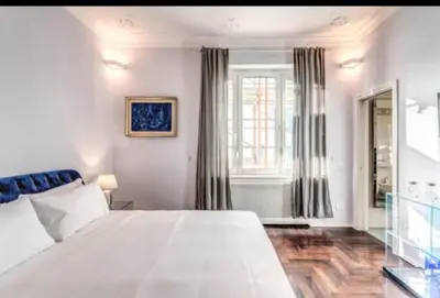 a bedroom with a large white bed and a window at Barberini Apartment in Rome