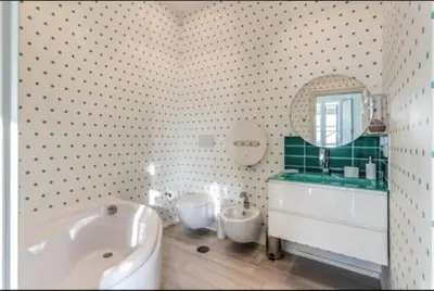 a bathroom with a tub and a sink and a mirror at Barberini Apartment in Rome