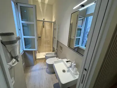 a bathroom with a sink and a toilet and a mirror at Settecento Guest House in Rome