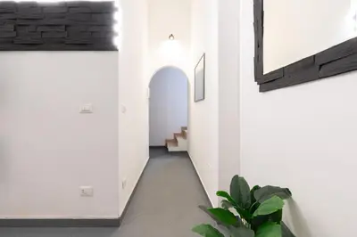 a hallway in a house with white walls and a plant at Imperial Garden Suite - 300 m to Metro B, A-C, Rome in Rome