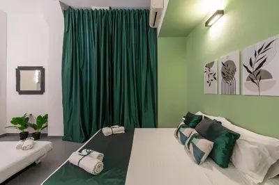 a bedroom with a bed with a green curtain at Imperial Garden Suite - 300 m to Metro B, A-C, Rome in Rome
