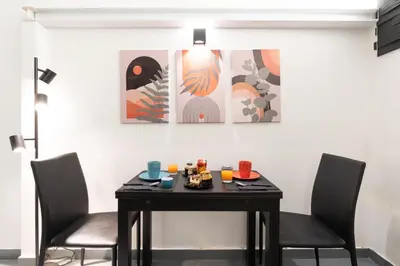 a table and two chairs in a room with paintings at Imperial Garden Suite - 300 m to Metro B, A-C, Rome in Rome