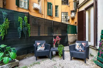 two chairs and a table in front of a building at Imperial Garden Suite - 300 m to Metro B, A-C, Rome in Rome