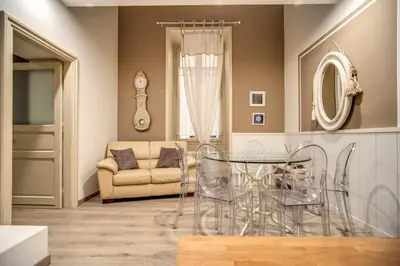 a dining room with a glass table and a couch at Trevi Miracle Suite in Rome