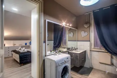 a bathroom with a washer and sink and a bed at Trevi Miracle Suite in Rome