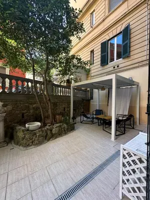 a patio with an umbrella and a tree in front of a building at Villa Borghese Home & Terrace in Rome