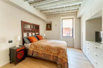 a bedroom with a bed and a television in it at Zenaria Trastevere, Zen Design in Heart of Rome in Rome