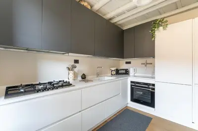 a kitchen with white cabinets and a stove at Zenaria Trastevere, Zen Design in Heart of Rome in Rome