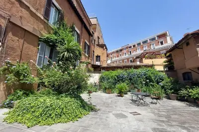 a courtyard with plants and a table and a building at Al moro in Rome