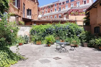 a patio with a table and chairs and plants at Al moro in Rome