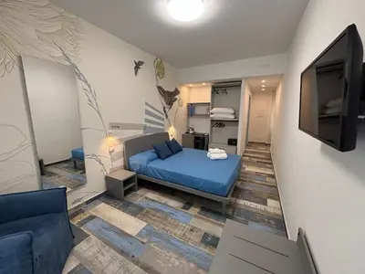 a bedroom with a blue bed and a flat screen tv at My Secret Room in Rome