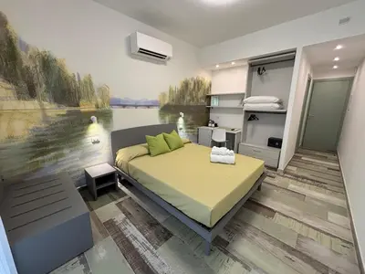 a bedroom with a bed and a painting of a lake at My Secret Room in Rome