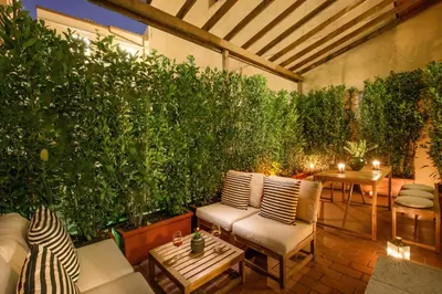 a patio with chairs and tables and plants at Daplace - Serenella Apartment in Rome