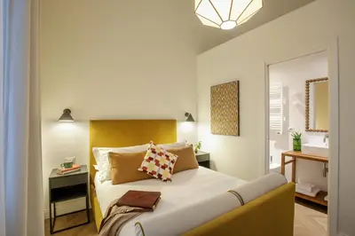 a bedroom with a bed and a mirror and a sink at Daplace - Serenella Apartment in Rome