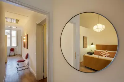 a mirror on a wall in a room with a couch at Daplace - Serenella Apartment in Rome