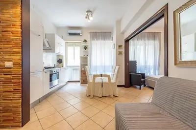 a living room with a table and a kitchen at Domus Romana Trieste in Rome