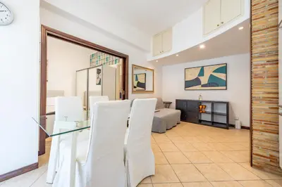 a living room with a glass table and white chairs at Domus Romana Trieste in Rome