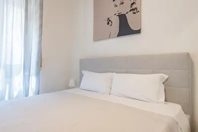a bedroom with a large bed with white sheets at Domus Romana Trieste in Rome