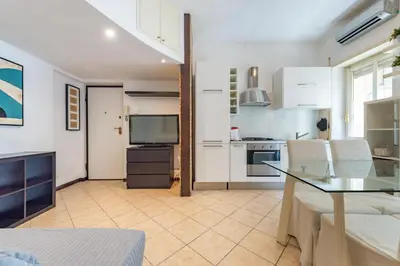 a living room with a table and a kitchen at Domus Romana Trieste in Rome