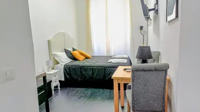 a bedroom with a bed and a table and a chair at little roma apartment in Rome