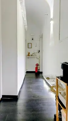 a hallway with white walls and a black floor at little roma apartment in Rome
