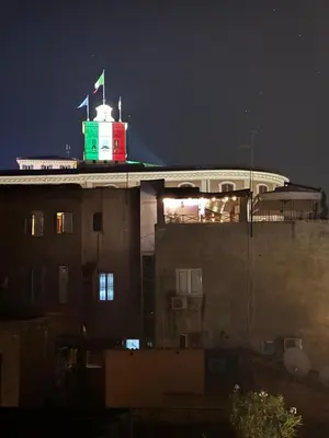 a building with a flag on top of it at night at Roman Dream Stay in Rome