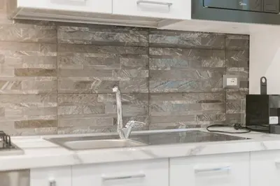 a kitchen with a sink and a stone wall at Domus Aura in Rome