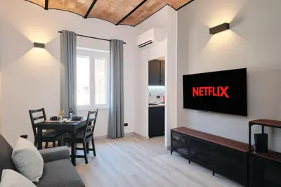 a living room with a couch and a tv on a wall at Circo Massimo Suite - In the heart of Testaccio in Rome