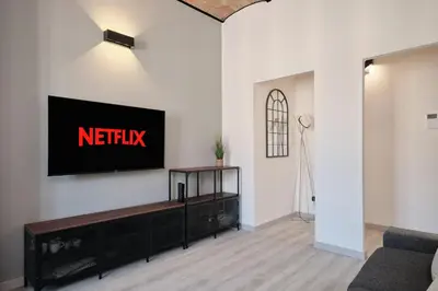 a living room with a tv on a wall at Circo Massimo Suite - In the heart of Testaccio in Rome