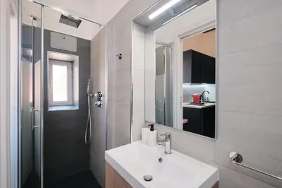 a bathroom with a sink and a shower and a mirror at Circo Massimo Suite - In the heart of Testaccio in Rome